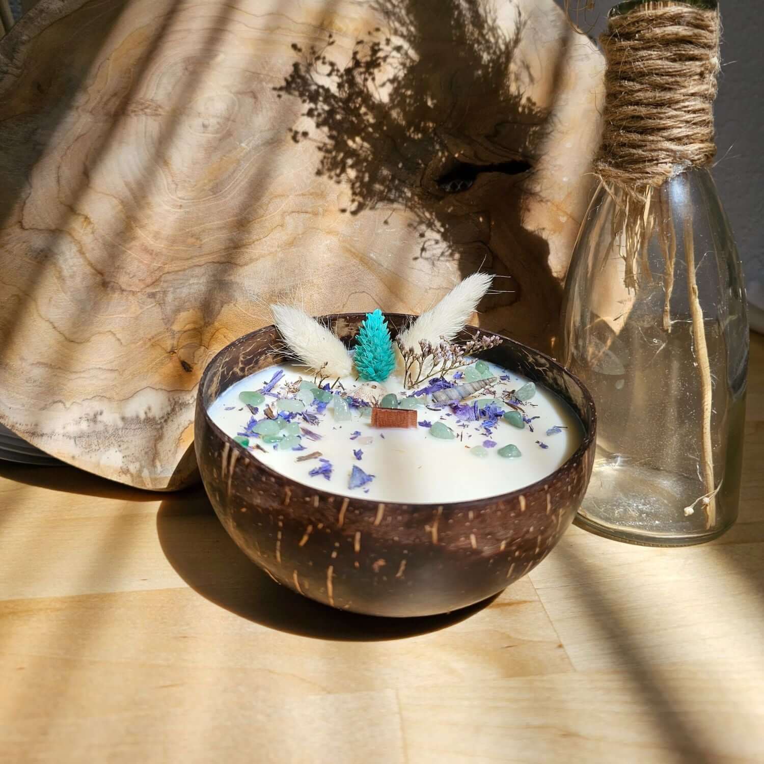 Monoï-Duftkerze in einem Kokosnussbehälter mit Halbedelsteinen